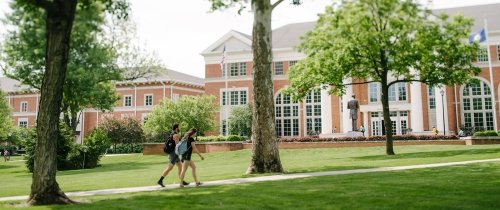Students walking on the ϲʿֱֳ campus in front of Crounce Hall