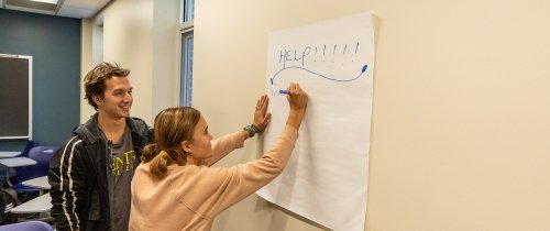 ϲʿֱֳ students writing help on a poster